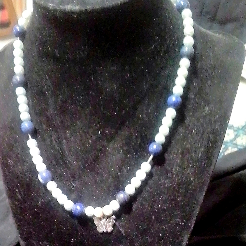 A 💙 blue pearl necklace with a little silver butterfly on it
